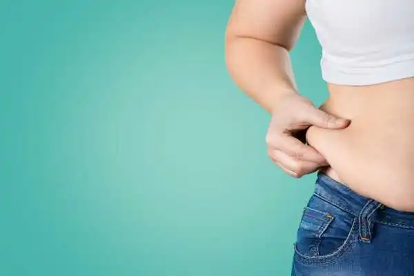 Image of woman pinching her love handles to show weight gain Hadleigh
